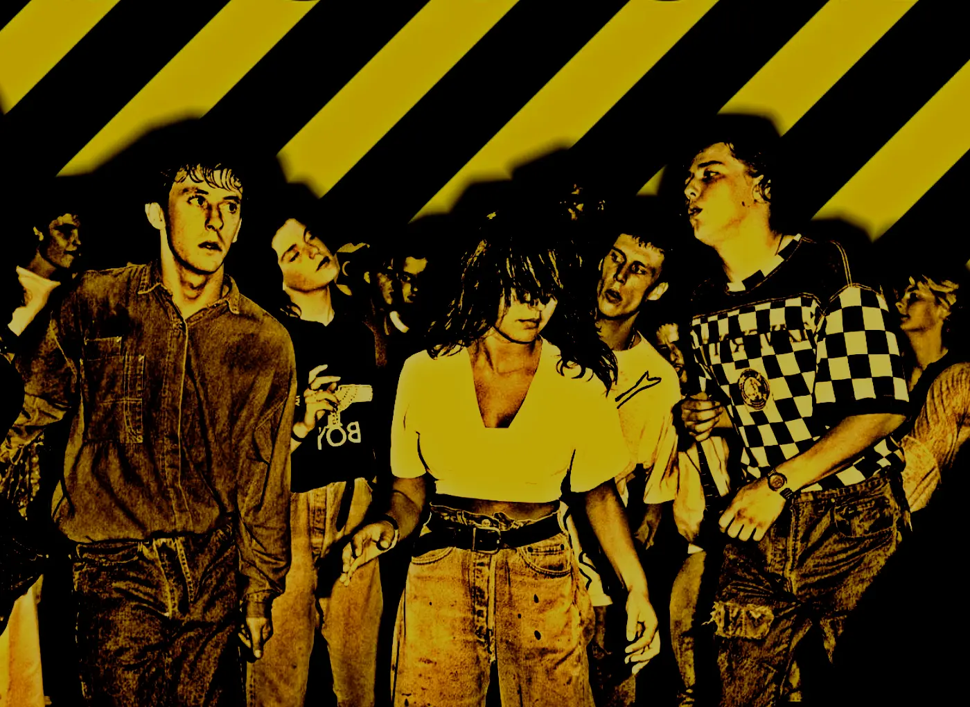 Group of young people dancing at a party with a bold yellow-and-black striped backdrop.