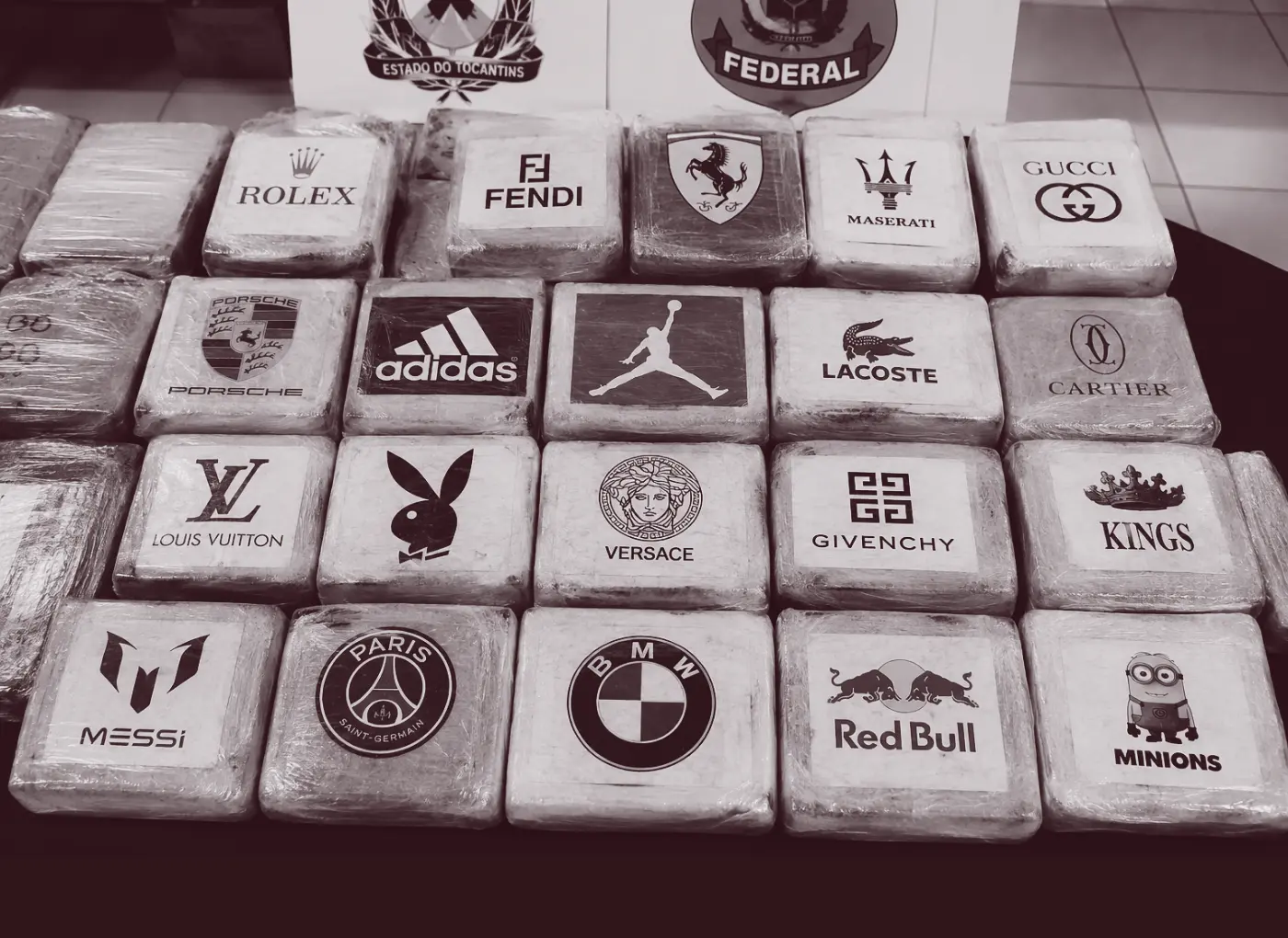 Grid of white blocks each showing a luxury brand logo (e.g., Rolex, Fendi, Ferrari, Maserati, Gucci) arranged in rows on a table.