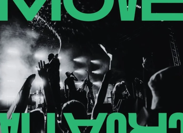 Black-and-white photo of a live concert with musicians performing on a smoky, lit stage while the crowd raises hands; oversized green text frames the image.